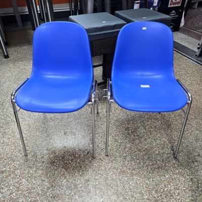 two blue chairs sitting next to each other in a room