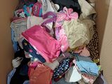 a cardboard box full of clothes and clothing on the floor