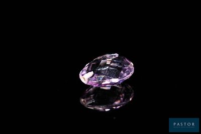 a close up of a purple diamond on a black surface