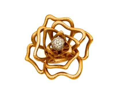 une image représentant une broche en forme de fleur en or et diamants sur fond blanc