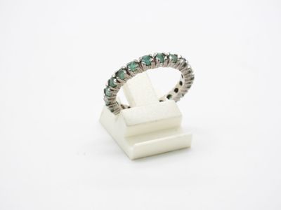un gros plan d'une bague ornée de pierres vertes