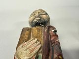a figurine of a man holding a book in his hands