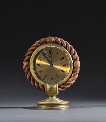 une horloge à l'ancienne, avec une corde autour du cadran, posée sur un socle