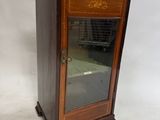 une petite armoire en bois munie d'une porte vitrée