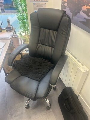 a black office chair with a black blanket on top of it