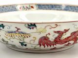 a bowl with a dragon on it on a white surface