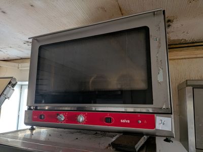 un téléviseur posé sur une cuisinière dans une cuisine