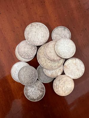 some silver coins are sitting on a wooden table