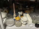 many glass dishes and cups on the shelf