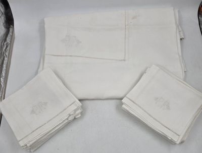 Plusieurs serviettes blanches sont posées sur une table, à côté d'une paire de ciseaux