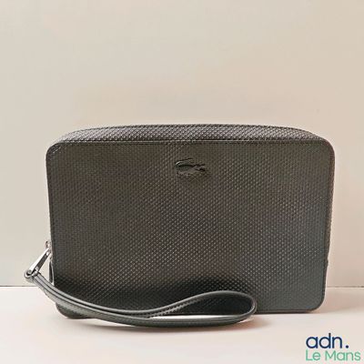un gros plan d'un sac à main noir posé sur une surface blanche