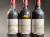 three bottles of red wine are lined up on a table