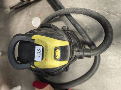 un aspirateur posé sur le sol à côté d'un tuyau