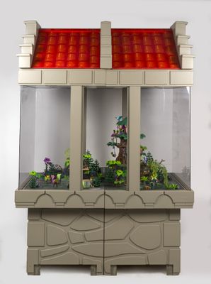 un petit aquarium contenant des plantes, posé sur une surface blanche