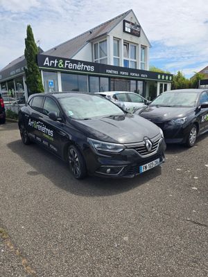 deux voitures garées sur un parking devant un immeuble