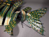 a green and yellow fish sculpture on a table