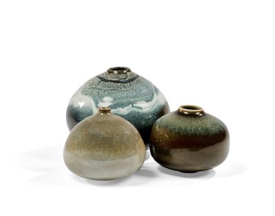 trois vases posés sur une surface blanche