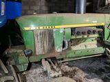 a green tractor that is parked in a garage
