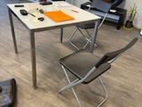 a room with a table, chairs, and a vacuum on the floor