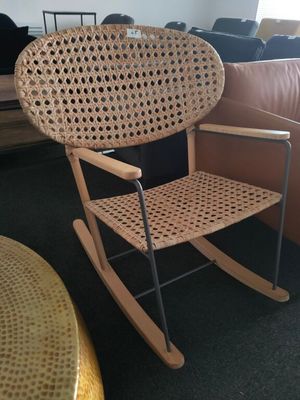 a wicker rocking chair in the corner of a living room