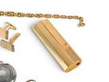 a gold lighter with a chain around it and some other items