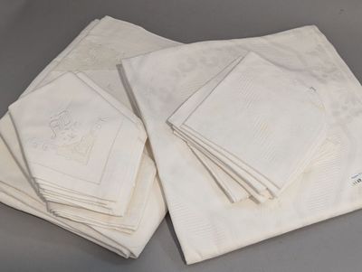 several folded white napkins with embroidered designs on them on a table