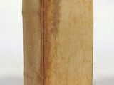 an old book that is sitting on a white surface