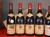six bottles of wine are lined up on a red table