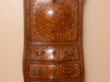 a tall wooden chest of drawers in the corner of a room