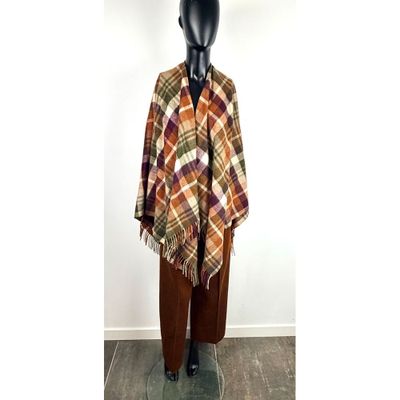couverture à carreaux posée sur un mannequin devant un mur blanc
