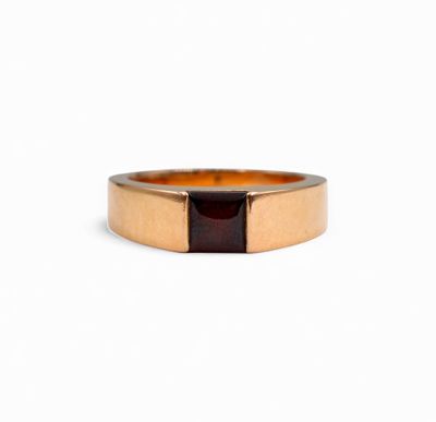 a close up of a gold ring with a red stone in the middle