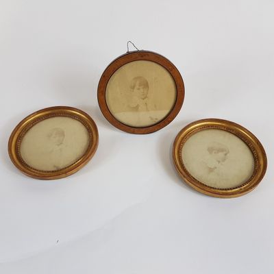trois portraits encadrés représentant une femme et un homme, dans un cadre doré