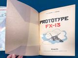 a hand holding an open book with a picture of a fighter plane on it
