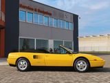 yellow sports car parked in front of a building on a cobblestone street