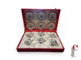 un coffret rouge contenant six tasses argentées et blanches