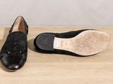 the black shoes are sitting on a wooden surface