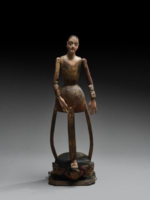 une statue en bronze représentant une femme assise sur un rocher
