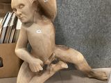 a statue of an angel sitting on the floor