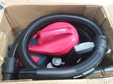 a pink blow dryer in a box with a black hose