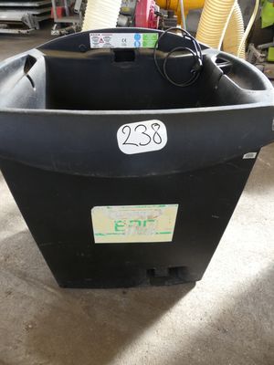 une poubelle noire portant un numéro, dans un garage