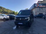 une camionnette noire garée sur un parking à côté d'un immeuble