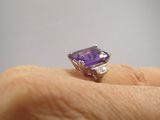 Quelqu'un tient une bague sertie d'un améthyste et de diamants.