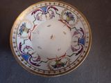 a white plate with a gold rim and a floral design on it