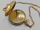 a gold pocket watch with a chain on a white surface