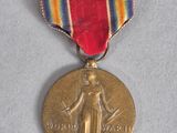 une vieille médaille entourée d'un ruban, posée sur un fond blanc