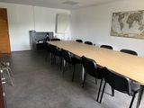 des tables et des chaises dans une pièce où est accrochée une carte au mur