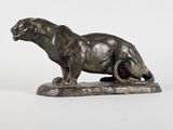 bronze statue of a lion on a rock on a white background