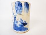 un vase bleu et blanc posé sur une surface blanche
