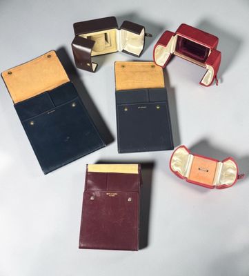 Quatre portefeuilles en cuir de couleurs différentes sont disposés sur une surface blanche