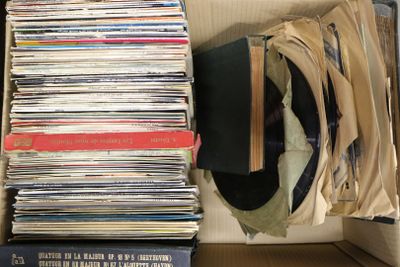 a box full of records and a hat on top of it